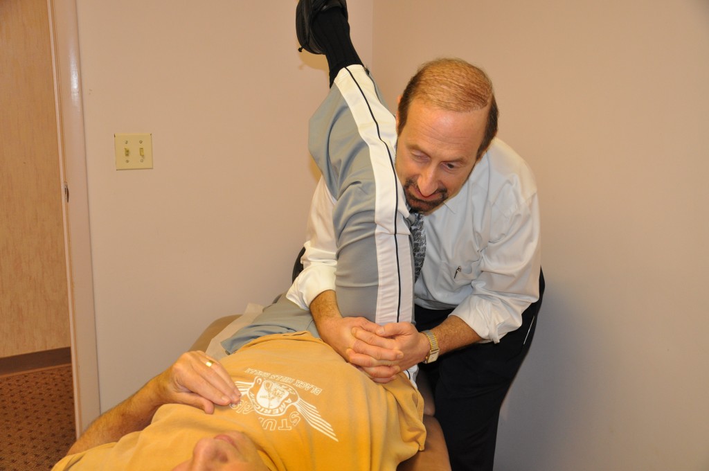 Dr. Miller giving a leg therapy on a patient.